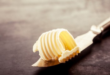 Butter on a Knife on Top of a Wooden Table